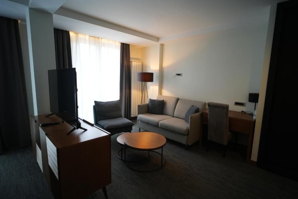 Living area with sofa, desk and television in a Hotel Pljevlja suite